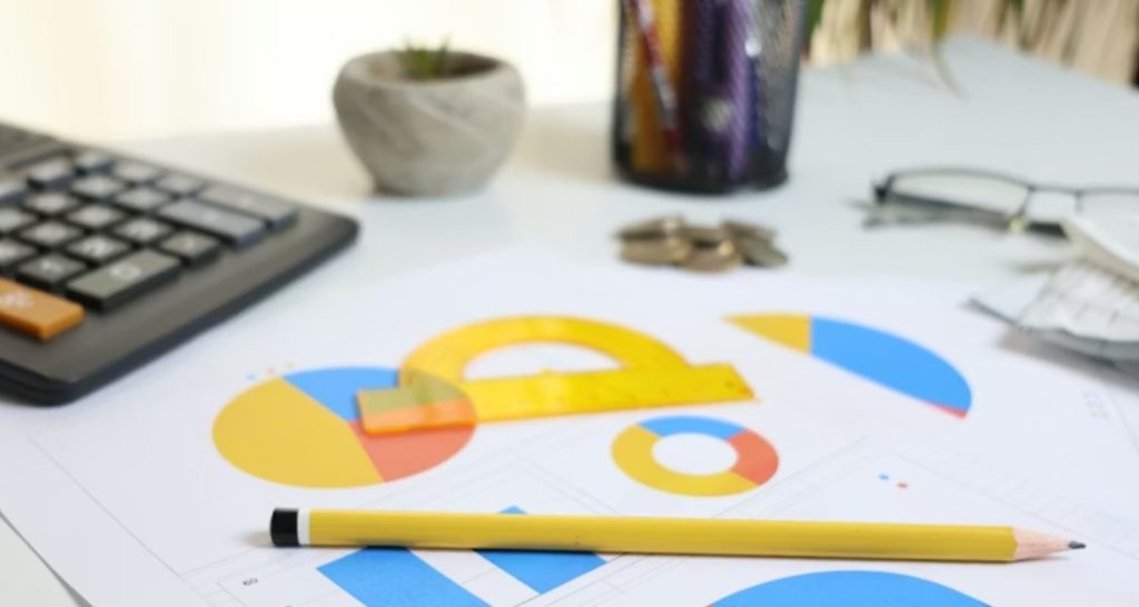 Esta foto apresenta um close-up de uma estação de trabalho focada em análise técnica e financeira.