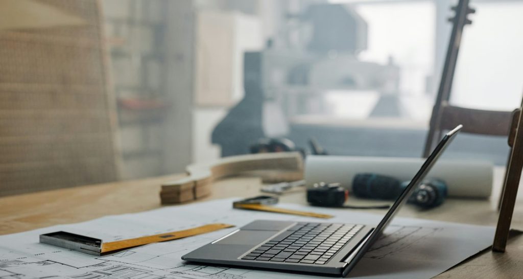 Esta é uma foto em close-up de uma mesa de trabalho ou bancada de um designer, carpinteiro ou arquiteto.