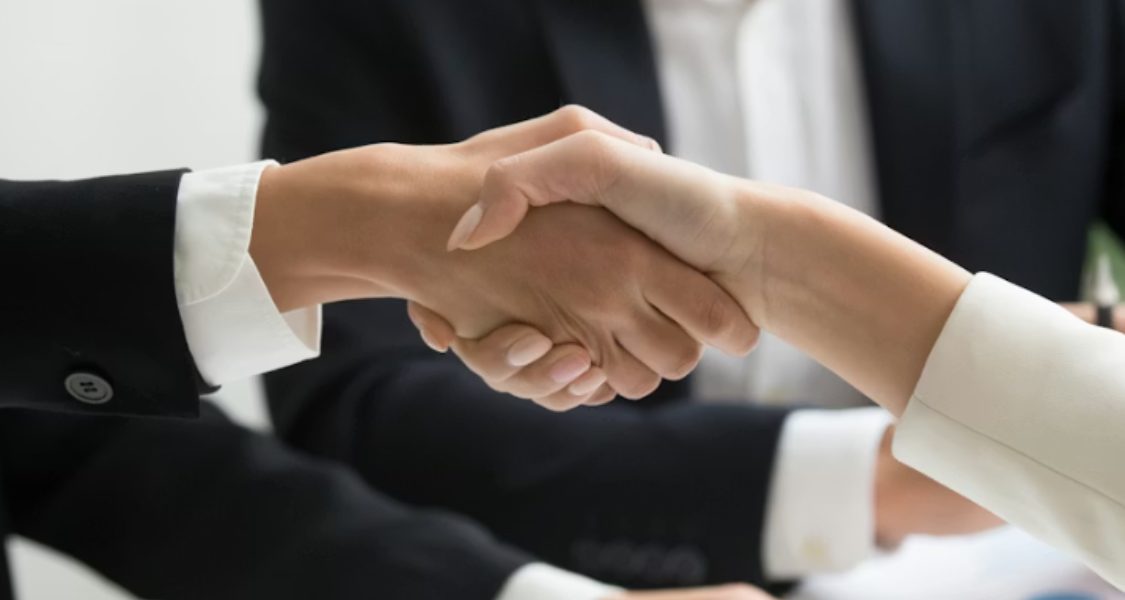 imagem captura um momento de interação profissional, simbolizando a conclusão de um acordo ou uma parceria de sucesso.