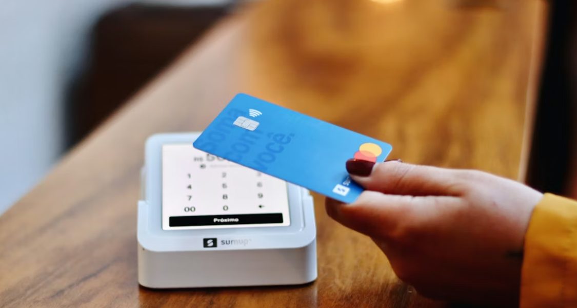 imagem foca em uma transação financeira presencial, complementando o ciclo de experiência do cliente ou de negócios.