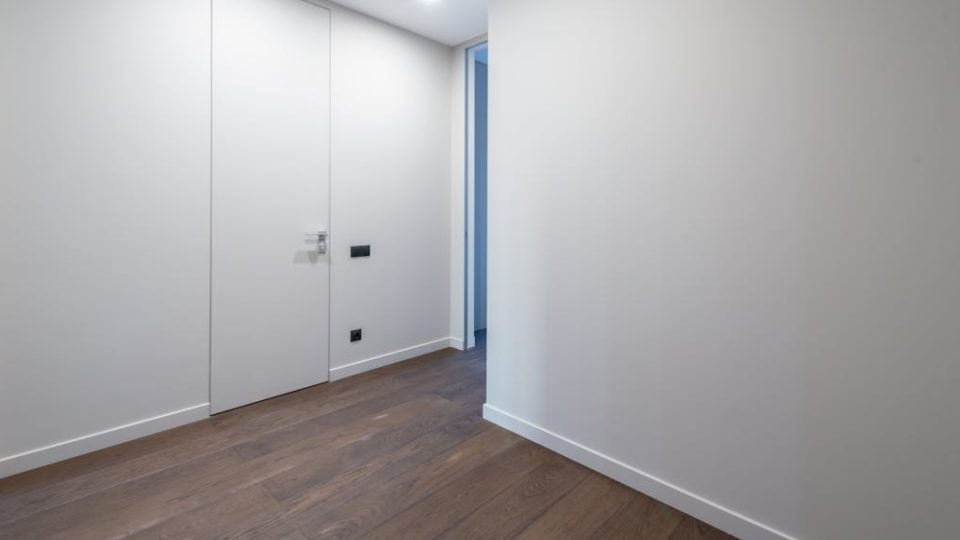 A imagem mostra um corredor interno com design moderno e minimalista.