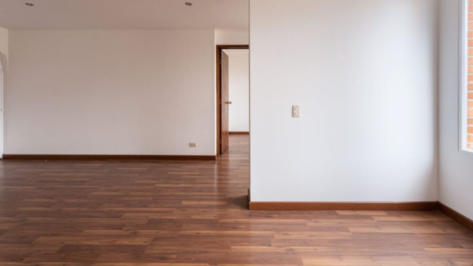 A imagem mostra um ambiente interno amplo e vazio, com acabamento residencial clássico e bem conservado.