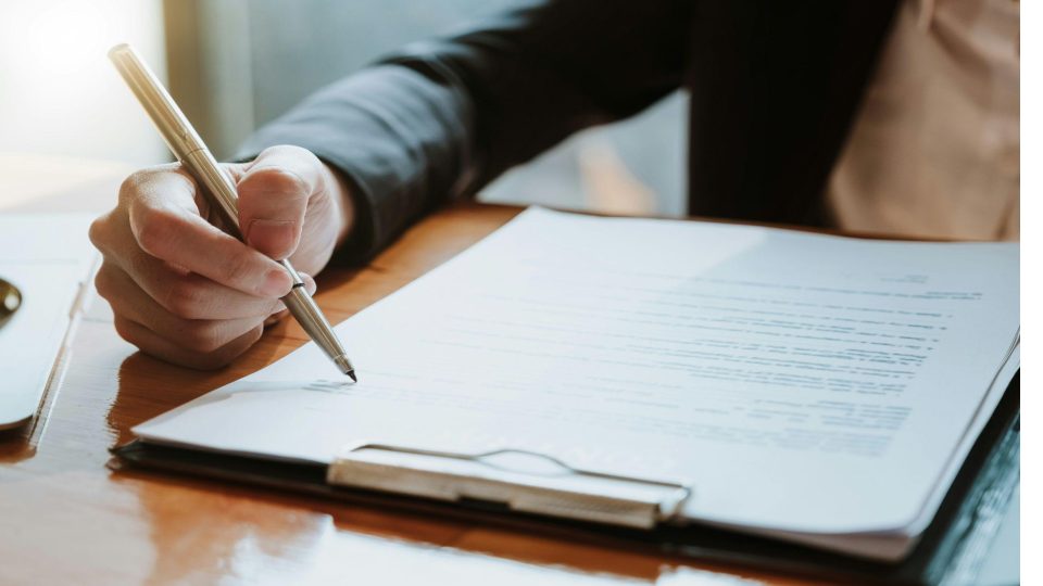 executivo em primeiro plano focado no preenchimento ou revisão de um formulário complexo.