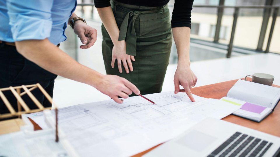 Esta imagem captura uma colaboração técnica detalhada, provavelmente entre profissionais de arquitetura, engenharia ou design de interiores.