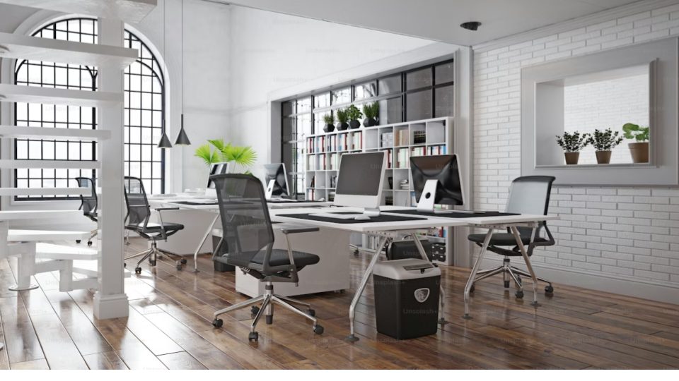 Esta imagem final apresenta um escritório em estilo loft, que combina elementos clássicos e industriais em um espaço de trabalho aberto e luminoso.