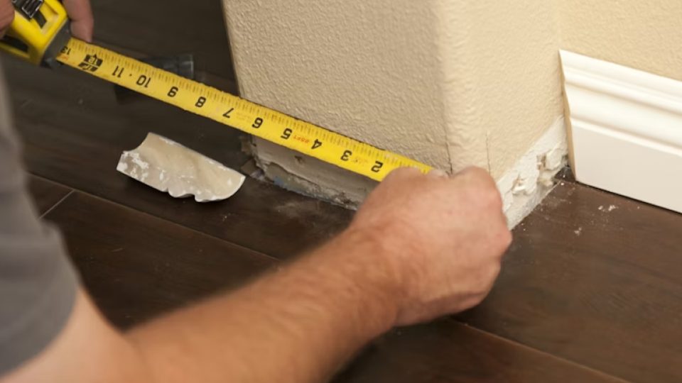 Esta imagem captura um momento de medição técnica durante uma obra ou reforma residencial.