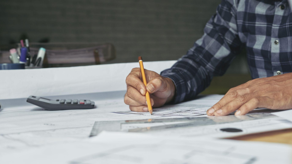 Esta imagem captura a essência do planejamento técnico e design arquitetônico, focando na etapa de desenho manual e precisão.