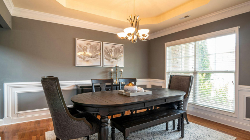 Esta imagem apresenta uma sala de jantar elegante e clássica, que utiliza contrastes de cores e texturas para criar um ambiente formal e acolhedor.