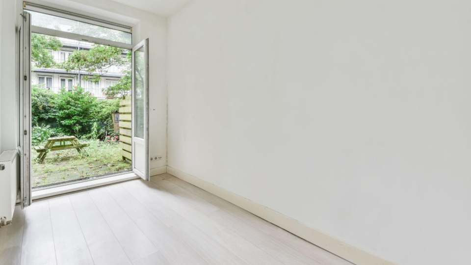 Um ambiente minimalista e muito claro, destacando a conexão com a área externa.