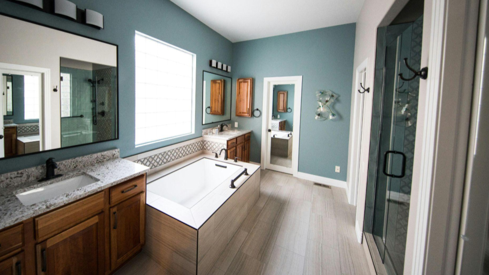 Este banheiro apresenta um design moderno, com cores mais frias e uma disposição que privilegia o relaxamento.