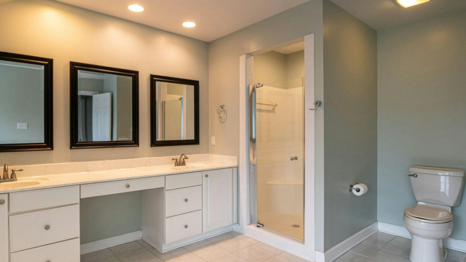 Esta imagem apresenta um banheiro amplo e bem iluminado, com uma organização que prioriza o espaço de bancada e a funcionalidade.