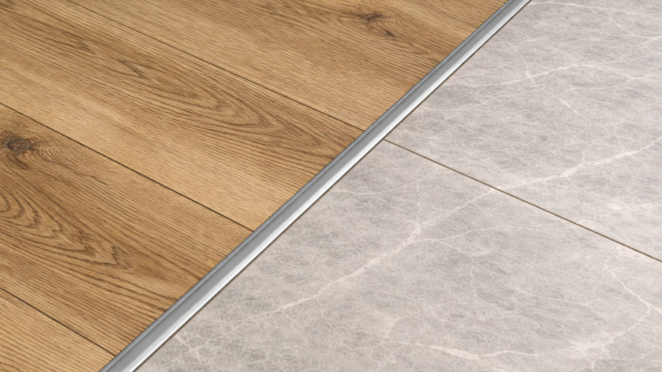 Esta imagem foca no encontro de dois tipos diferentes de revestimentos de piso, separados por um perfil de acabamento. A composição é dividida diagonalmente, criando um contraste visual interessante entre texturas e materiais.