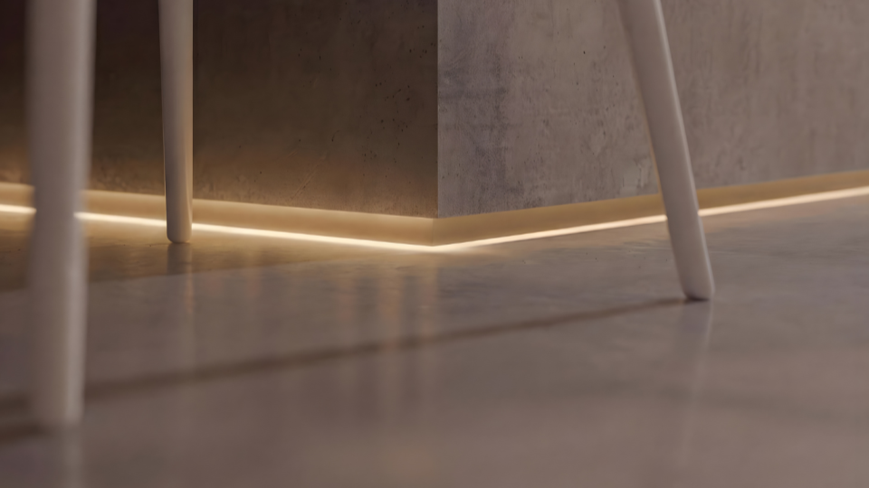 Uma imagem de close-up em ângulo baixo mostrando a base de uma parede ou balcão de concreto aparente.