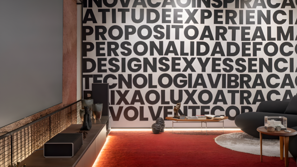 Sala de estar contemporânea com decoração elegante, tapete vermelho, mobiliário moderno e parede com tipografia em destaque.