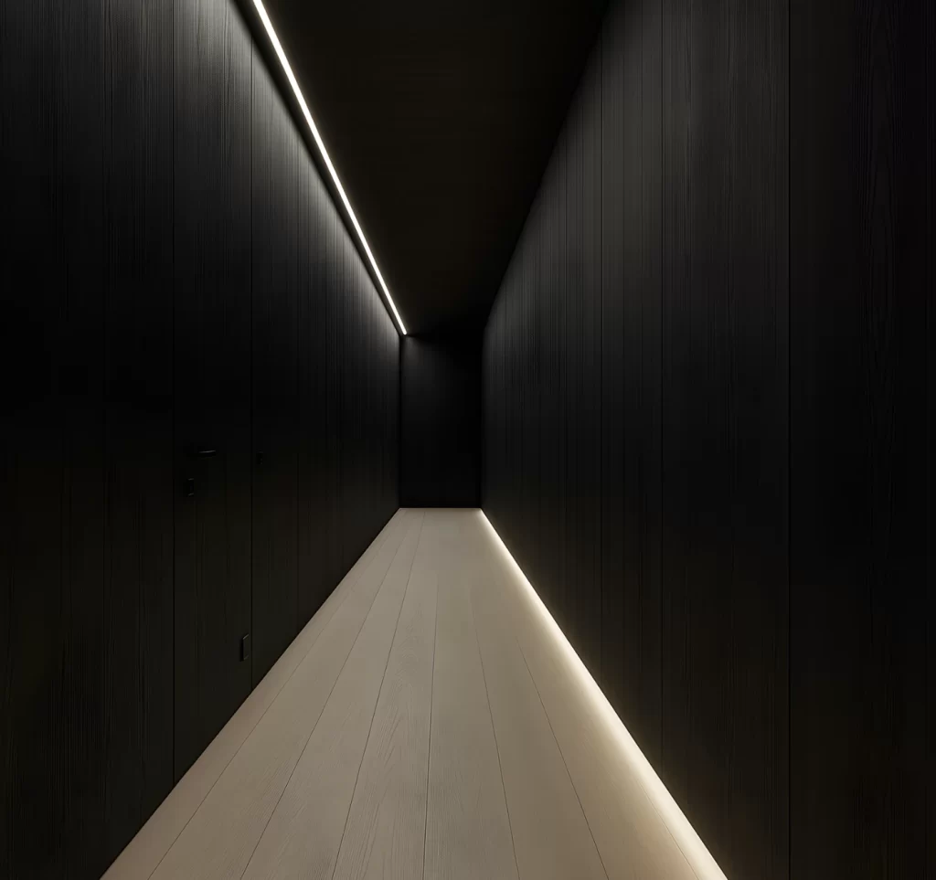 Corredor moderno com paredes escuras e ripadas, iluminação linear embutida no teto e faixa de luz contínua no chão, criando efeito de profundidade e ambiente minimalista.