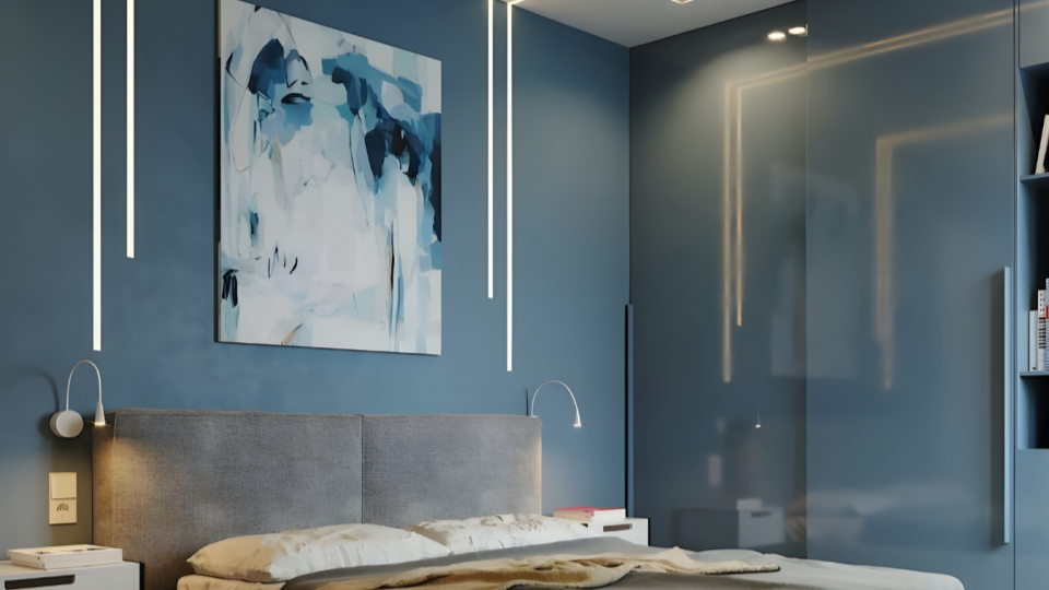 Um ambiente residencial elegante com parede azul, cabeceira de cama estofada em cinza, iluminação LED embutida em perfis verticais, luminárias de leitura curvas e um quadro de arte abstrata.