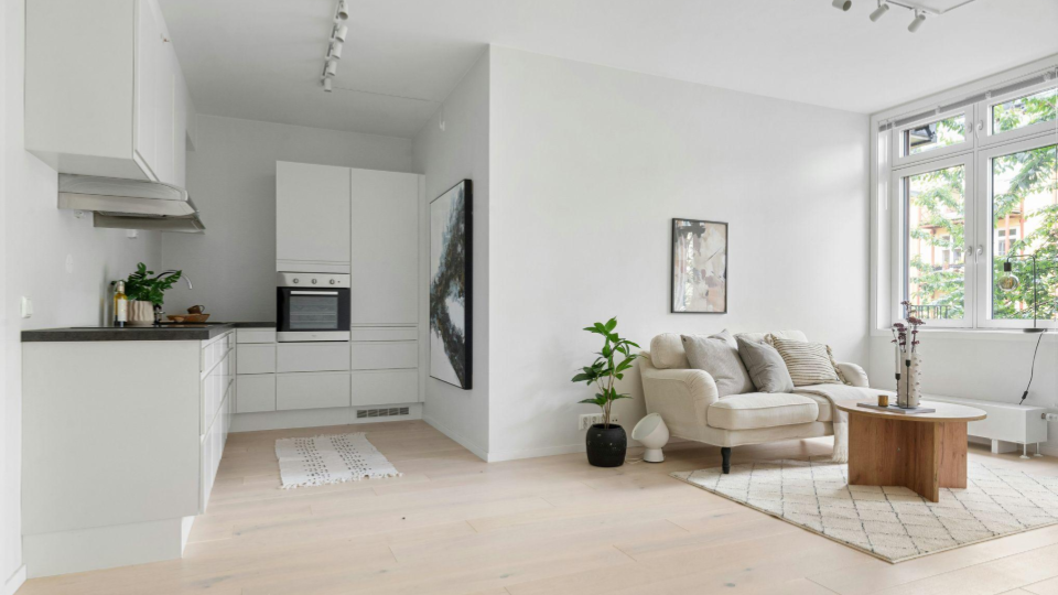 Escandinavo / Japandi. Conceito aberto integrando sala e cozinha, priorizando o aconchego com tons claros, madeira natural, tecidos macios, plantas e muita iluminação natural.