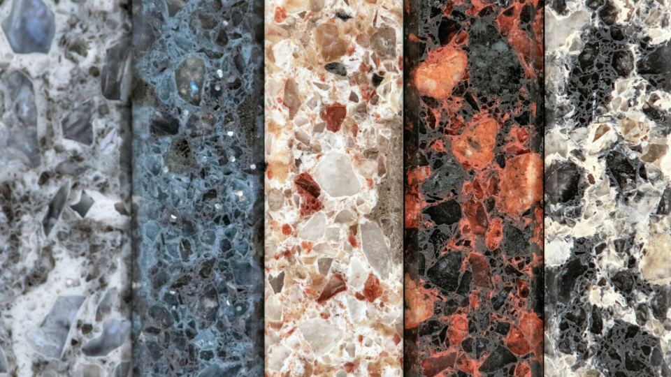 Cinco tiras verticais mostrando diferentes amostras de granito/terrazzo com texturas e cores distintas (cinza, azul, bege, vermelho e preto).